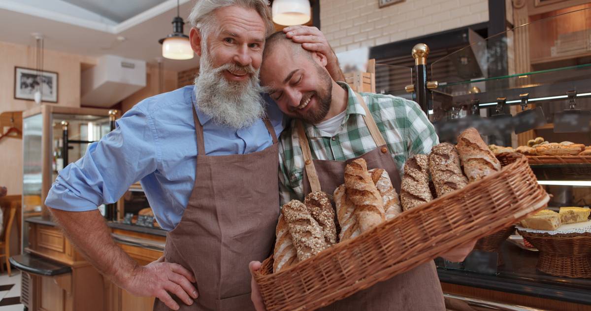 Vader knuffelt zoon in zijn bakkerij